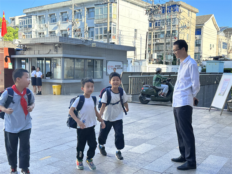陆路老师在校门口欢迎学生.jpg