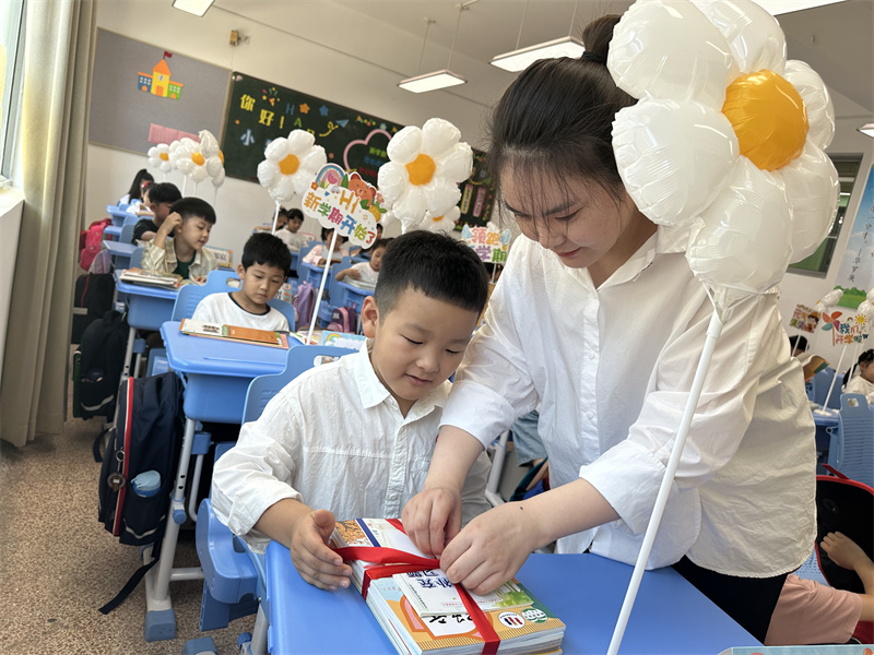 周媛媛老师帮助新生整理书本.jpg