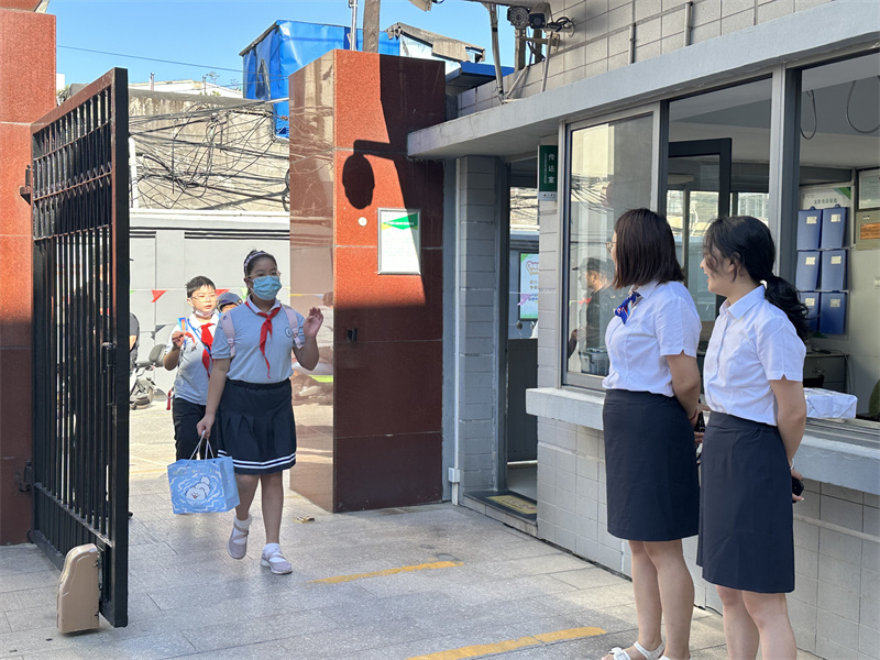 老师们在校门口欢迎学生的到来.jpg